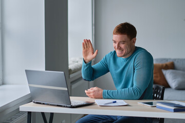Business man having video call on laptop computer. Focused millennial man working in modern office or studying online at home.