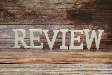 Review Word alphabet letters on wooden background