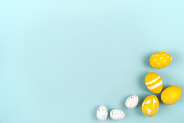 Easter eggs in yellow and white on a pastel blue background. Flat lay, top view.