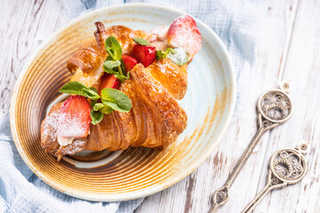 Fresh french croissant with strawberry. Freshly baked croissant.