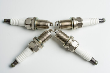 four spark plugs for a car on a white background