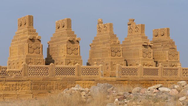 Group of beautiful ancient early islamic carved sandstone cenotaphs or tombs on a platform in Chaukhandi necropolis cemetery near Karachi, Sindh, Pakistan