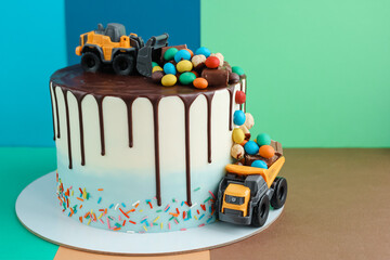 Birthday colorful cake for little boy with toy cars and colorful candies decorations. Holiday,...