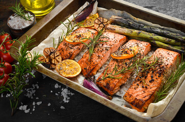 Baked Salmon with rosemary, lemon and vegetables. Recipe. Seafood. Side view Free space for text.