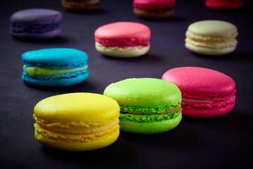 Sweet Macaron of different colors on an darke background
