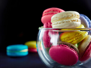 Sweet Macaron of different colors on an darke background