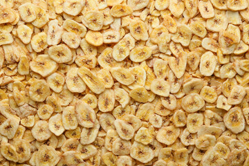 Tasty crispy banana chips as background