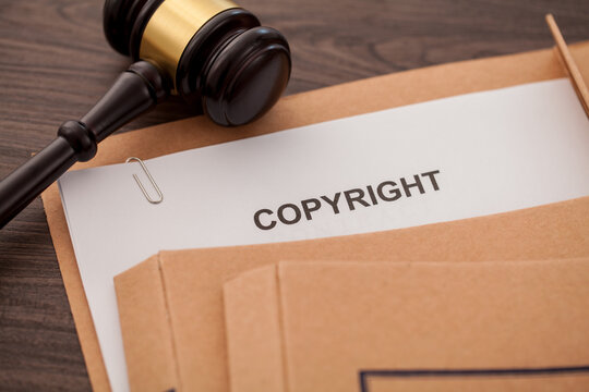 copyright document and folder with judge gavel on desk.