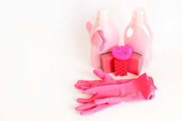 Pink set of products for washing and cleaning on the while background with copy space for text. Rubber gloves, gel bottles, sponges and rags. Household cleaning concept