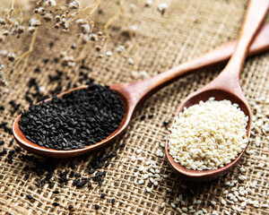 Black and white sesame seeds in a spoons