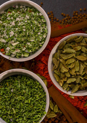 a still life of colorful spices that encompass green, black, and colorful spices. Photo suitable for cookbook, cover, kitchen calendar, etc.