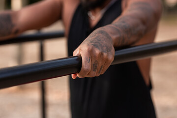 Fototapeta na wymiar african american athlete boy does calisthenics fitness exercises on bars in park