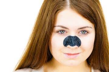 Woman applying pore strips on nose