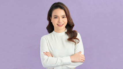 Photo of serious young lady with arms crossed dressed in white dress standing and posing over purple background.