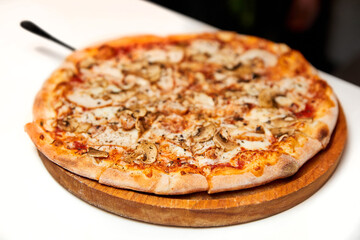 Fresh pizza with bacon, mushrooms and cheese on a light background. Close-up, selective focus