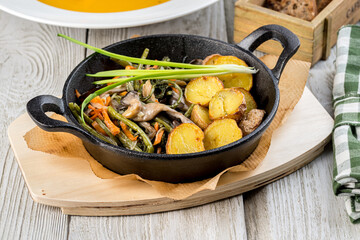 Baked potatoes in a cast iron skillet with onions