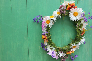 Flower door wreath. Midsummer flower crown on rustic wooden background with copy space. DIY floral wreath. Midsummer night dream decoration
 - obrazy, fototapety, plakaty