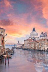 Obraz na płótnie Canvas Stunning view of the Venice skyline with the Grand Canal and Basilica Santa Maria Della Salute in the distance during a dramatic sunrise. Picture taken from Ponte Dell’ Accademia, Venice, Italy.