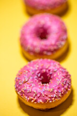 Fototapeta na wymiar Homemade circle donut with pink icing and rainbow sprinkles
