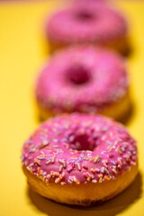 Homemade circle donut with pink icing and rainbow sprinkles