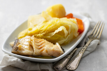 boiled cod fish with boiled vegetables and egg on white dish
