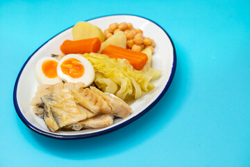 boiled cod fish with boiled vegetables and egg on white dish