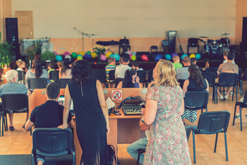 Children's holiday in elementary School. Children on stage perform in front of parents. image of blur kid 's show on stage at school , for background usage. Blurry. toned