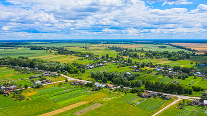 Fototapeta na wymiar Aerial view over beautiful suburb in wide valley, in the summer. Top view to the small village with a beautiful green landscape.