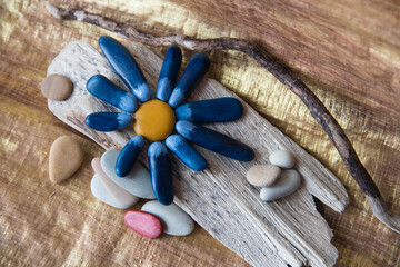 crafts made of wood, stones and colored paints. Flowers.