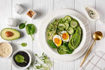 bowl with quinoa, greens, avocado and boiled egg