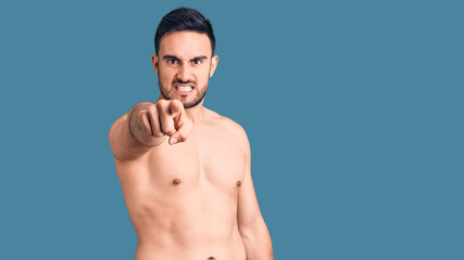 Fototapeta premium Young handsome man wearing swimwear pointing displeased and frustrated to the camera, angry and furious with you