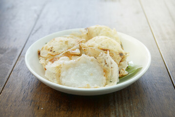 Knmcrk (Kanom Krok) Thai dessert filled with sweet coconut milk in a white container.