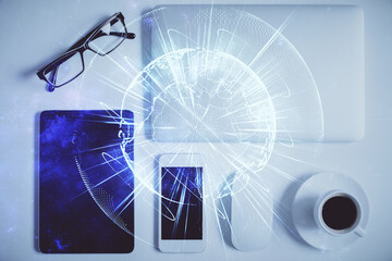 Double exposure of business theme hologram over desktop with phone. Top view. Mobile international...