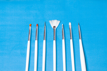 
white makeup brushes on a blue background