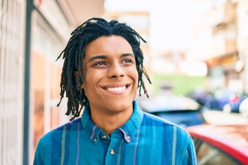 Young african american man smiling happy looking to the side at street of city.