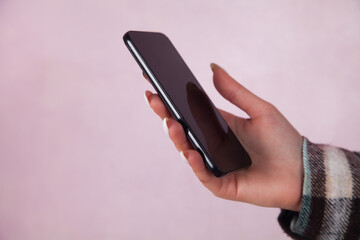 Caucasian woman holding a mobile phone. Woman using the internet.