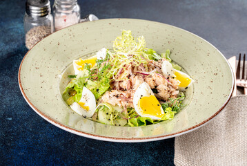 Salad with omul in a white plate on a blue background