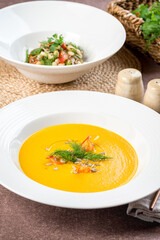 Carrot soup in a white plate filmed for the menu