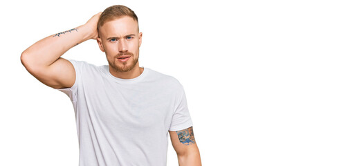 Young irish man wearing casual clothes confuse and wonder about question. uncertain with doubt,...