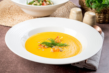 Carrot soup in a white plate filmed for the menu