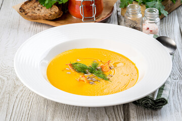 Carrot soup in a white plate filmed for the menu