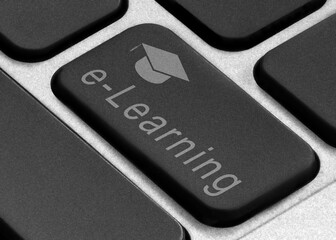 Online learning concept. Close up photo of a laptop button with the inscription and with the image of a student degree hat.