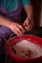 Obraz na płótnie Canvas housewife mixing flour with her hands in the bowl. preparing ingredients for traditional homemade cakes