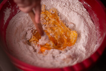 mixing flour with egg and milk by the housewife. preparing ingredients for traditional homemade cakes