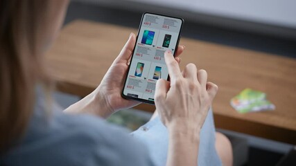 A woman is shopping online from home. A housewife chooses a smartphone in an online store. - Powered by Adobe