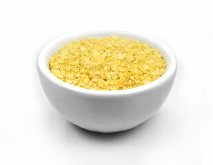 Millet flakes in a bowl isolated on white bacground.