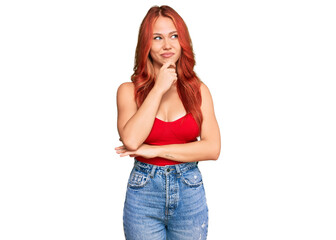 Young redhead woman wearing casual clothes with hand on chin thinking about question, pensive expression. smiling with thoughtful face. doubt concept.