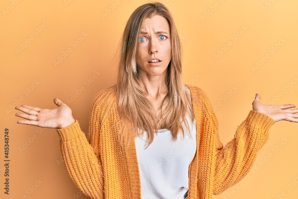 Sticker Beautiful caucasian woman wearing casual clothes clueless and confused with open arms, no idea and doubtful face.