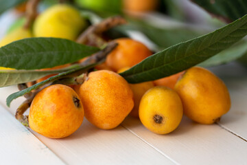 fresh loquats on white wooden background