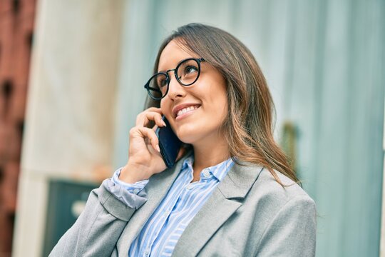 Young hispanic businesswoman smiling happy tlking on the smartphone at the city.